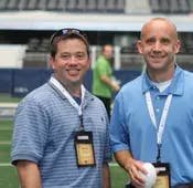Aaron Rowe of Edelman Financial and and Eric Clarke take the field of the Dallas Cowboys Stadium 